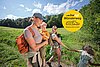 Eine Familie wandert mit drei Kindern durchs Grüne einen bwegt-Wanderweg entlang