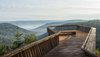 Aussichtsplattform mit Blick auf See und Wald.