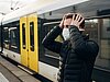 Mann vor einem Zug schlägt sich die Hände an den Kopf.