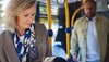 Eine Frau schaut während der Busfahrt auf ihr Mobiltelefon