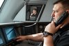 Ein Triebfahrzeugführer im Führerstand eines Zuges spricht in einen Telefonhörer.