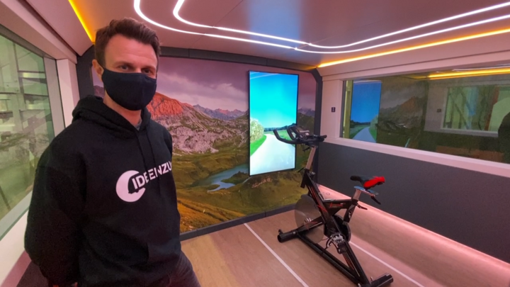 Mann steht vor einem Home-Trainer im Zug.