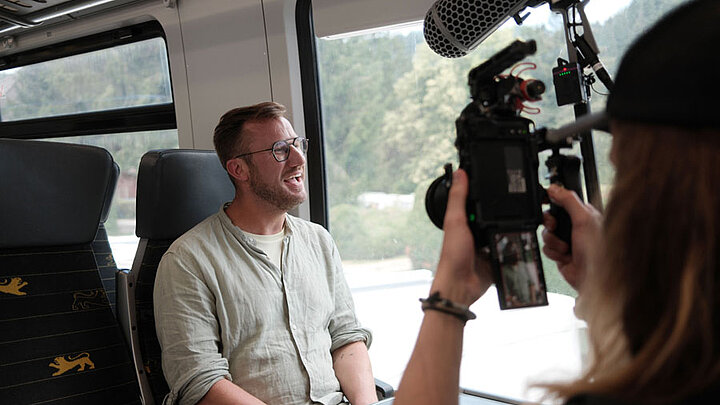 Sternekoch Sören Anders beim Videodreh in einem bwegt-Zug auf dem Weg, Gastronomie in Baden-Württemberg zu entdecken
