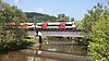 Der Freizeitexpress „Naturpark Obere Donau“ fährt über eine Brücke mit See