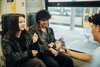 Junge Menschen, die lachend in der Bahn sitzen und Popcorn essen