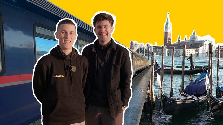 Zwie junge Männer stehen vor einem Zug.