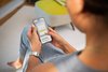 Eine Frau schaut sich das Fahrplanauskunft-Widget auf dem Smartphone an