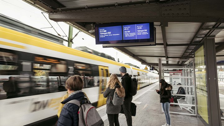 Personen warten auf einen einfahrenden bwegt-Zug