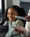 Ein kleines Mädchen lächelt bei der Fahrkartenkontrolle in einem bwegt-Zug.