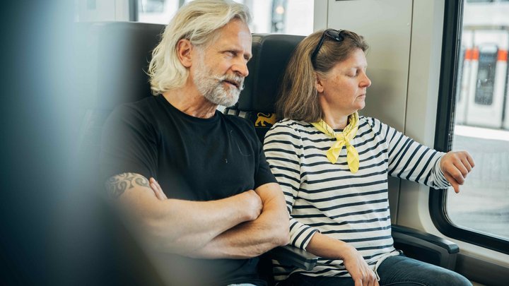 Ein Mann und eine Frau sitzen nebeneinander in der Bahn.