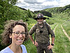 Frau steht neben einem Ranger in der Natur.