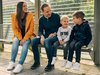 Familie mit zwei Kindern sitzt am Bahnsteig auf einer Bank.