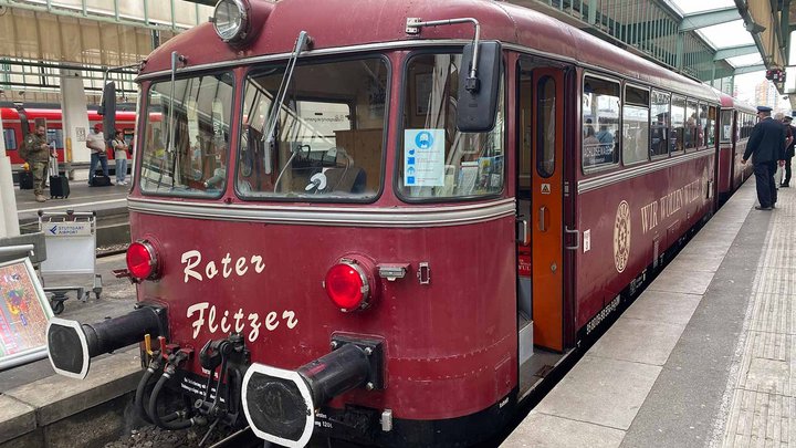 Rote altmodische Bahn steht am Bahnhof.