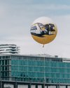 Ein gelber bwegt-Ballon mit einem Zug- und Busmotiv