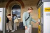Ein junger Mann kauft sich ein Ticket an einem Fahrautomaten.
