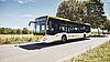 Ein bwregiobus fährt durch eine grüne Landschaft.