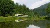 Freizeitexpress-Zug fährt hinter einem See entlang
