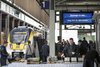 Bahnsteig mit Personen und Zug.