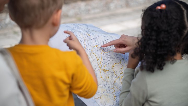 Zwei kleine Kinder schauen auf eine bwegt-Streckennetzkarte