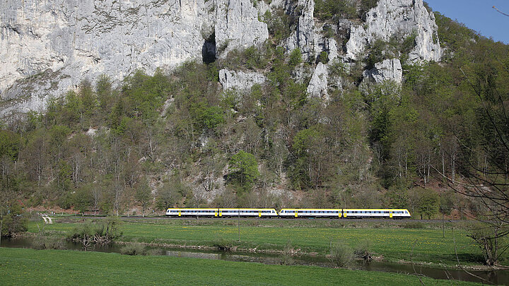 Der Freizeitexpress „Donautal“ vor einer halbbewachsenen Gebirgswand