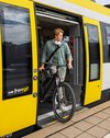 Ein junger Mann steigt mit seinem Fahrrad aus einem bwegt-Zug.