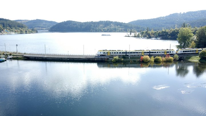 Gelber bwegt Zug fährt über eine Seebrücke