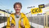 Ein Mann in gelber Kleidung steht mit seinem Handy am Bahnhof. Links und rechts von ihm steht jeweils ein bwegt-Zug.