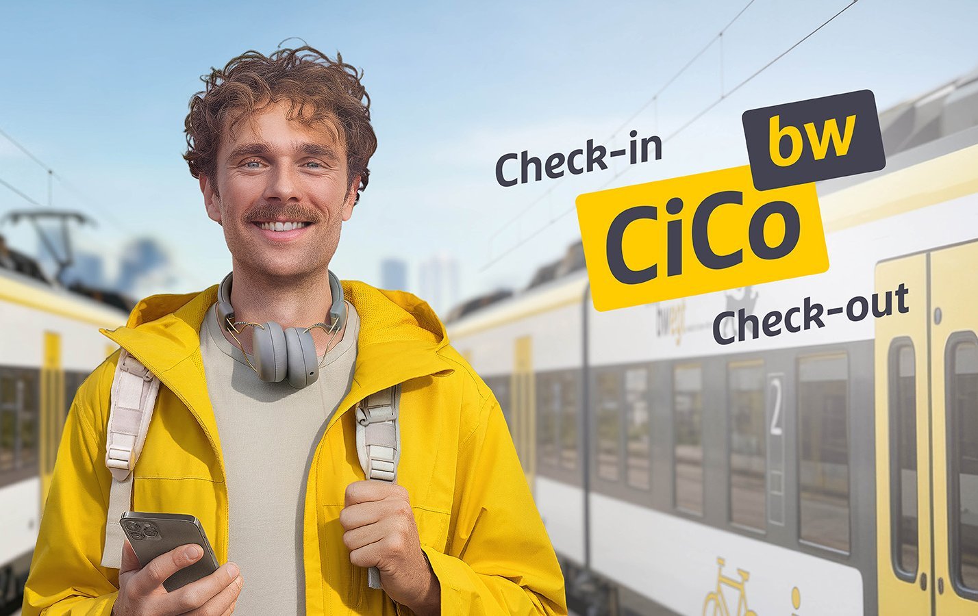 Ein Mann in gelber Kleidung steht mit seinem Handy am Bahnhof. Links und rechts von ihm steht jeweils ein bwegt-Zug.