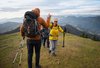 Eine Wandergruppe gibt sich ein High-Five, während sie gemeinsam durch die Natur wandert.