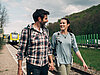 Paar geht Hand in Hand am Bahnsteig entlang.