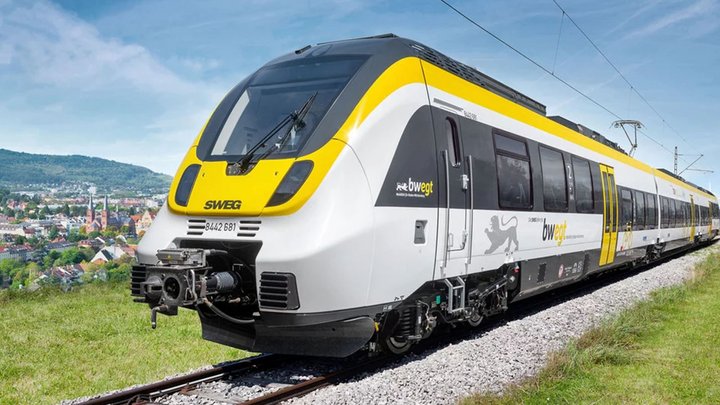 Ein bwegt-Zug fährt durch eine grüne Landschaft