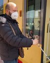 Blinder mit Gehstock öffnet Tür zur Straßenbahn.
