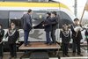 Offizielle von der Bahn ziehen eine schwarze Folie von einem bwegt-Zug ab und enthüllen die Aufschrift Crailsheim.