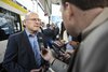 Verkehrsminister Winfried Hermann steht vor einer Bahn und wird von der Presse interviewt.