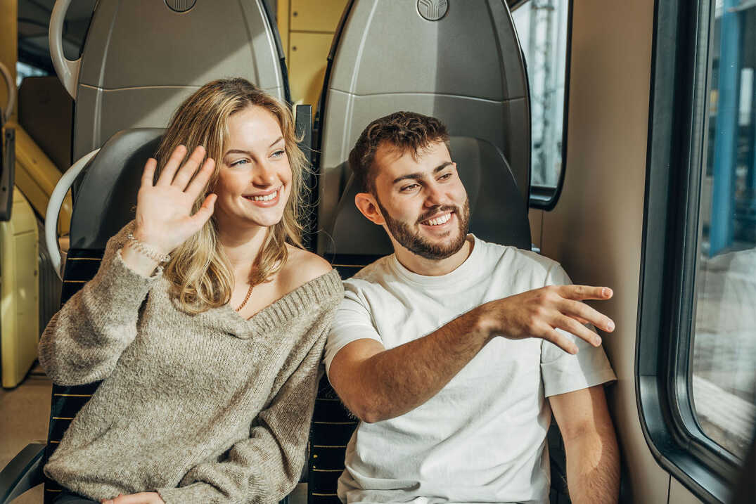 Ein junges Paar sitzt am Fenster im Zug