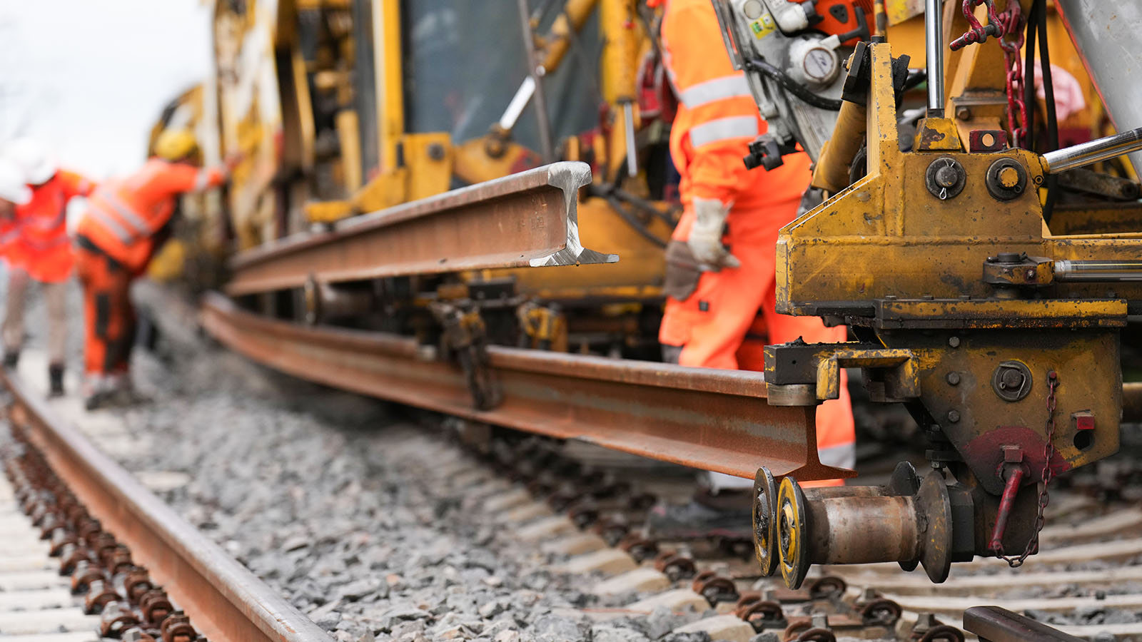 Eine Baustelle mit drei Mitarbeitern und einem gelben Bagger