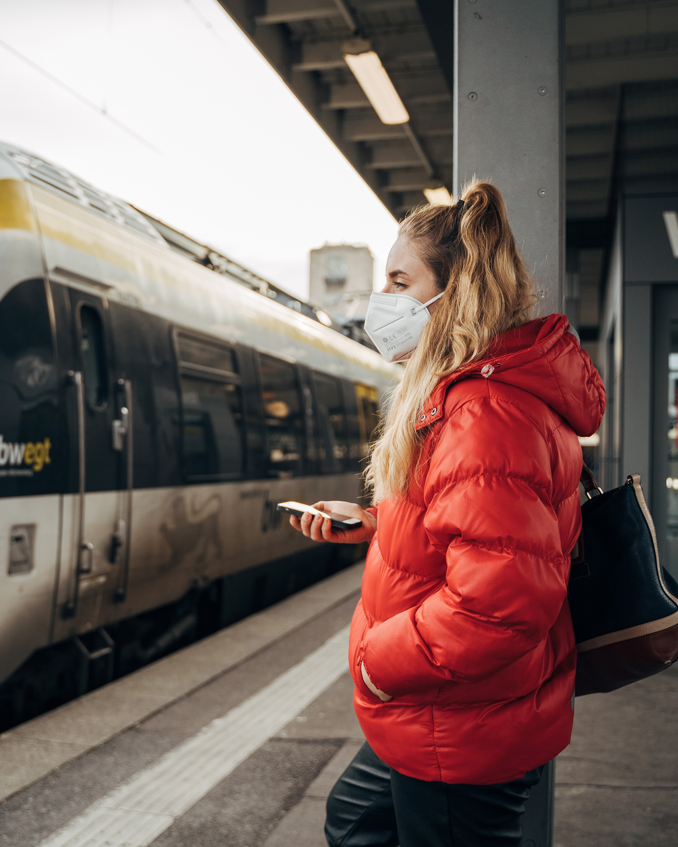Frau steht an auf einem Bahngleis.