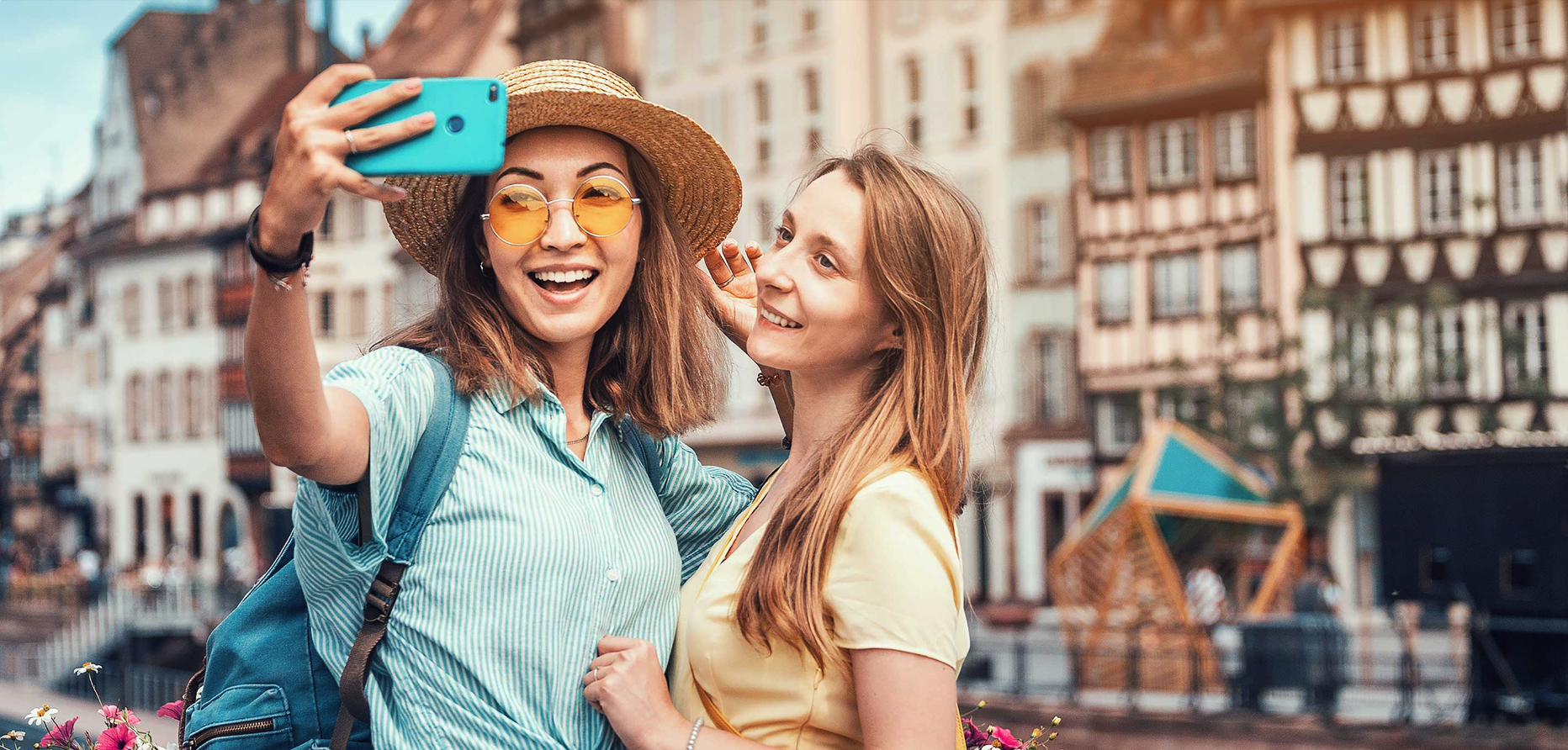 Zwei junge Frauen machen ein Selfie in einer französischen Altstadt