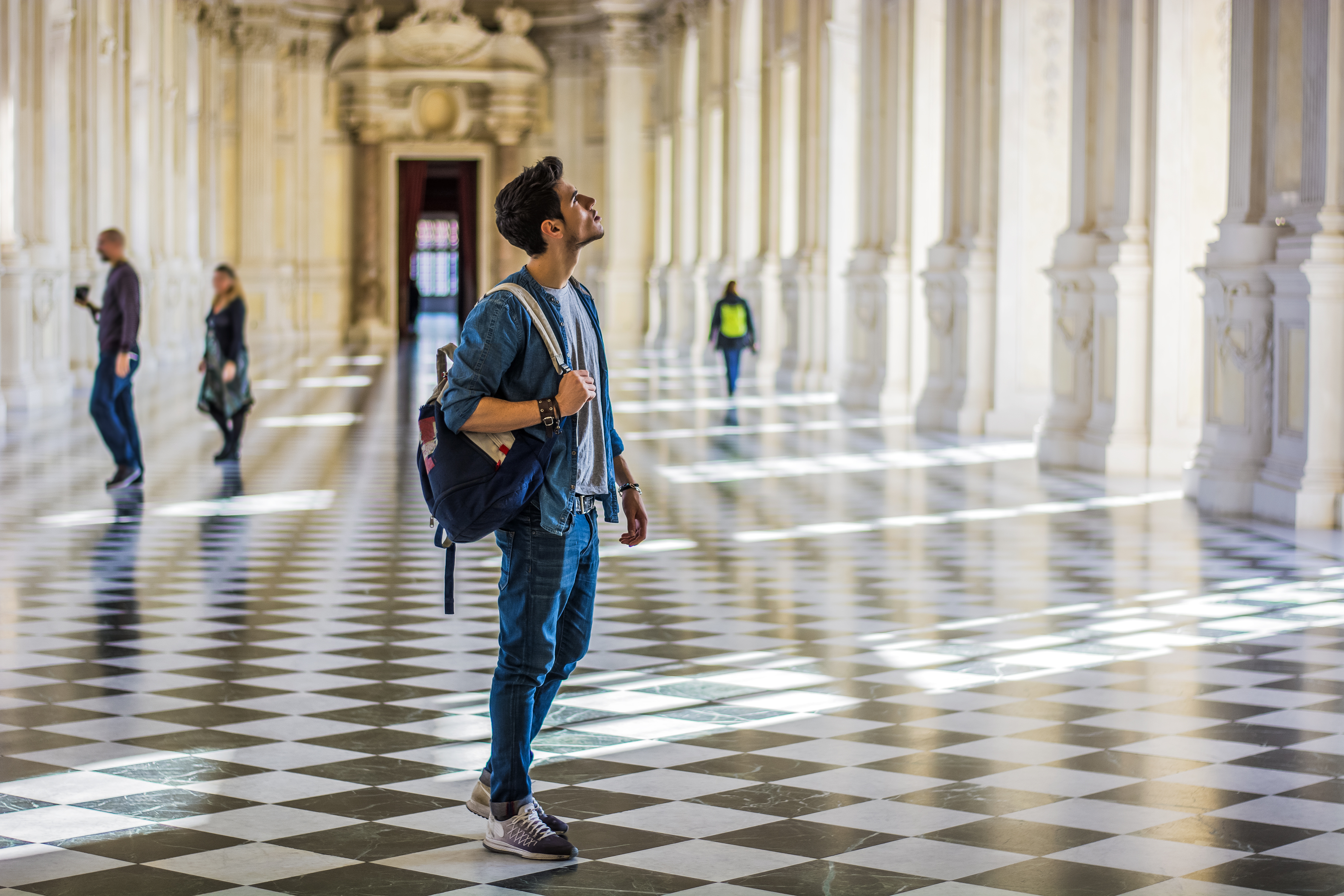 Ein Junger Mann steht in einem Museum und schaut an die Decke